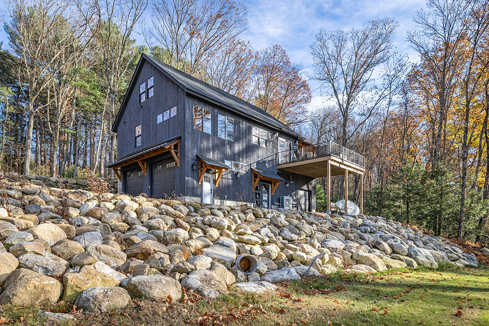 Modern garage with wooden awning and dark siding