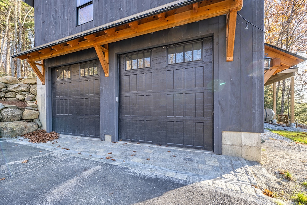 Modern garage with wooden awning and dark siding