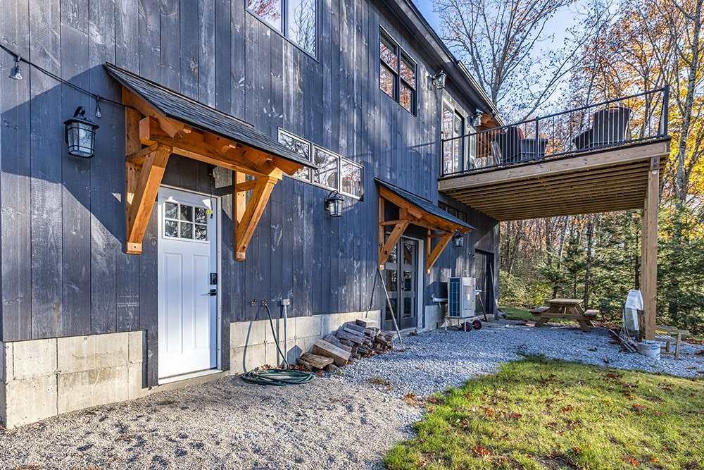Modern garage with wooden awning and dark siding