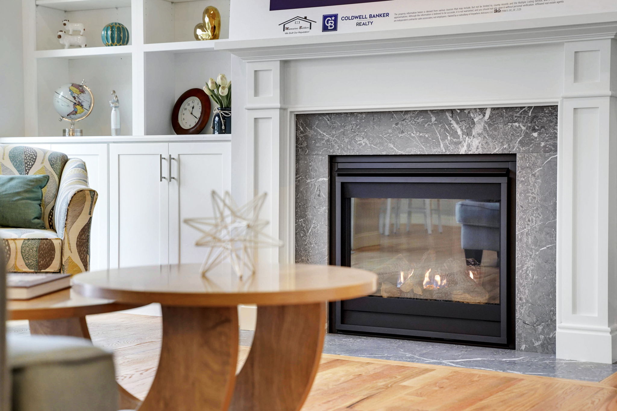 Close-up of gas fireplace with decorative stone surround and white built-in shelving