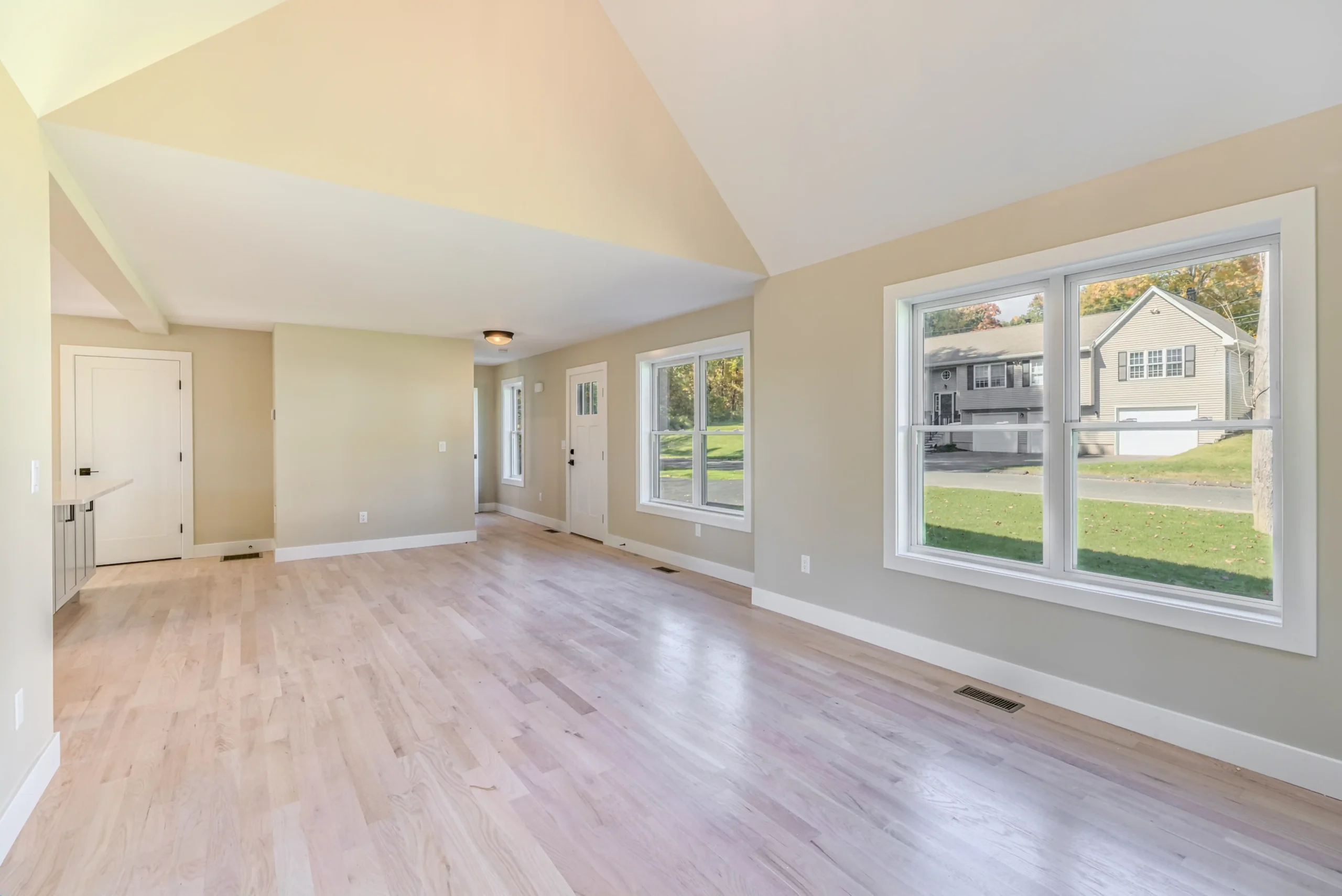 Crystal Lake Home 5 Elm Street Bright Unfurnished living room with vaulted ceiling and large windows overlooking the yard
