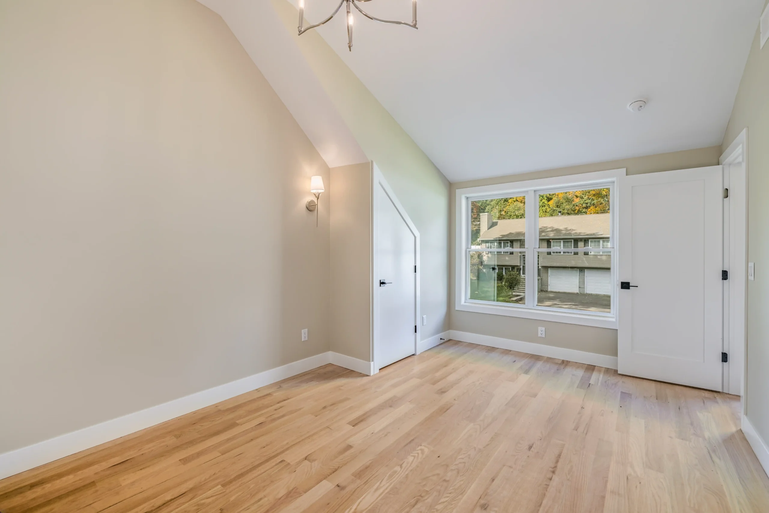 Crystal Lake Home 5 Elm Street Bright interior hallway with sloped ceiling, wall sconces and large window