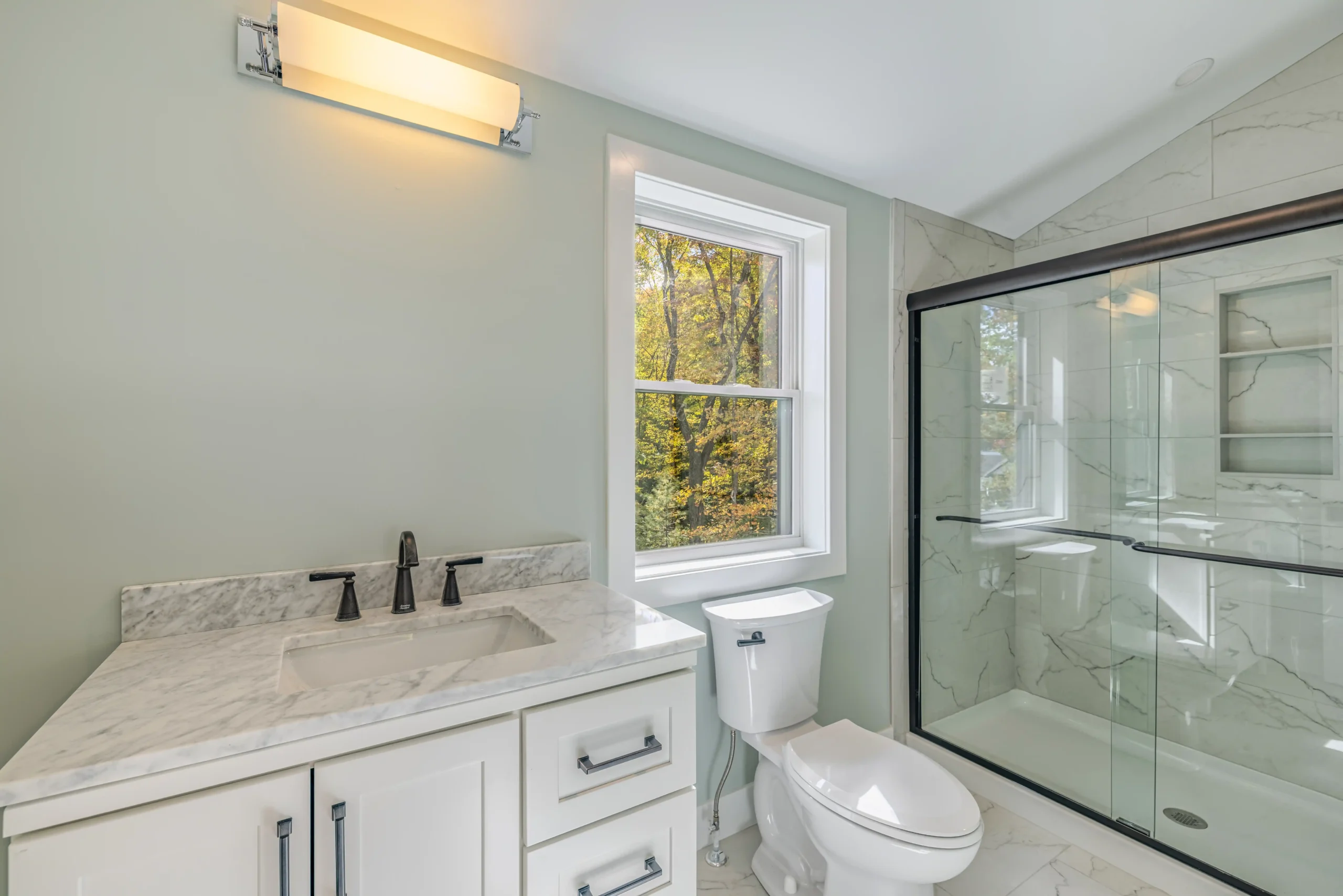 Crystal Lake Home 5 Elm Street Bathroom with white vanity, large window and glass-enclosed shower