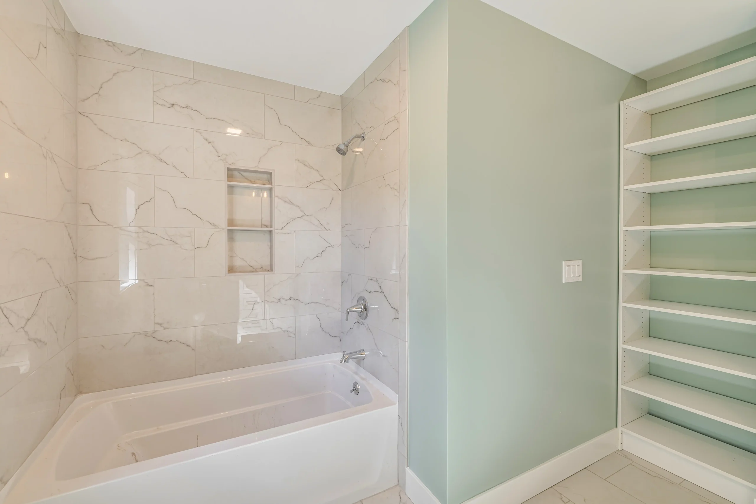 Crystal Lake Home 5 Elm Street Modern walk-in shower with white marble-look tile walls and built-in shower niche