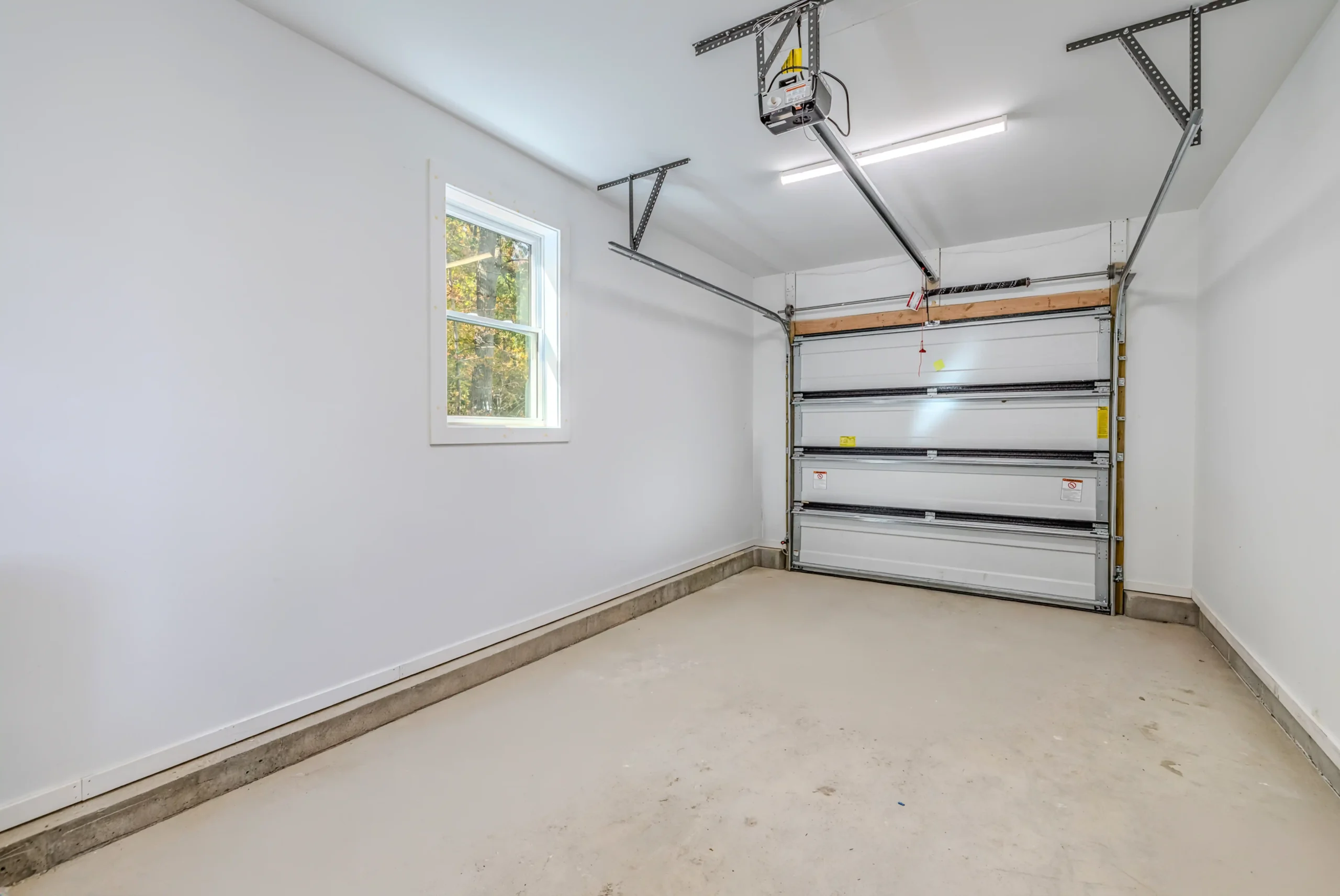 Crystal Lake Home 5 Elm Street Clean garage interior with overhead door, concrete flooring and side window