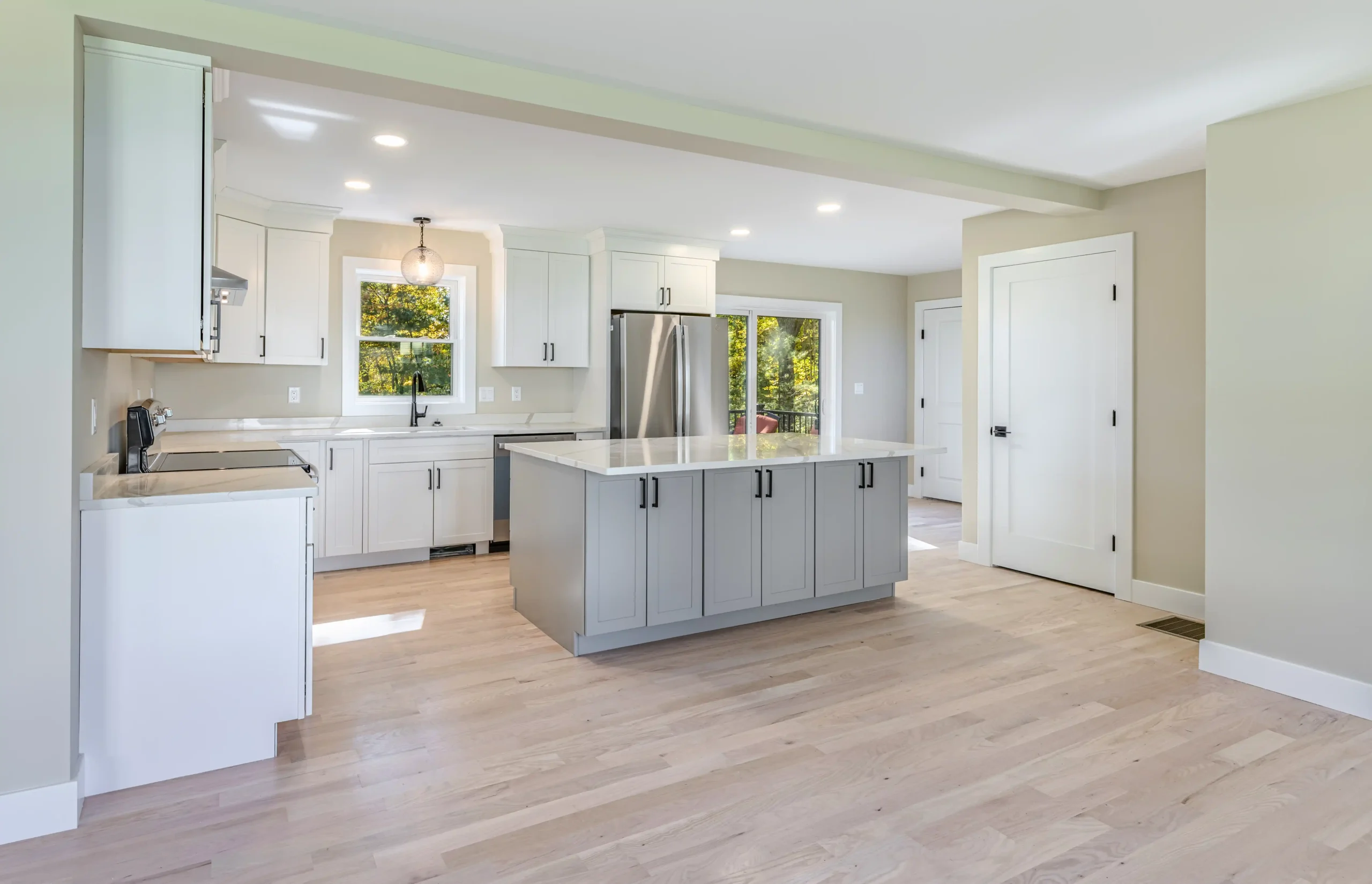 Crystal Lake Home 5 Elm Street Bright White kitchen with gray center island, stainless steel refrigerator and recessed lighting
