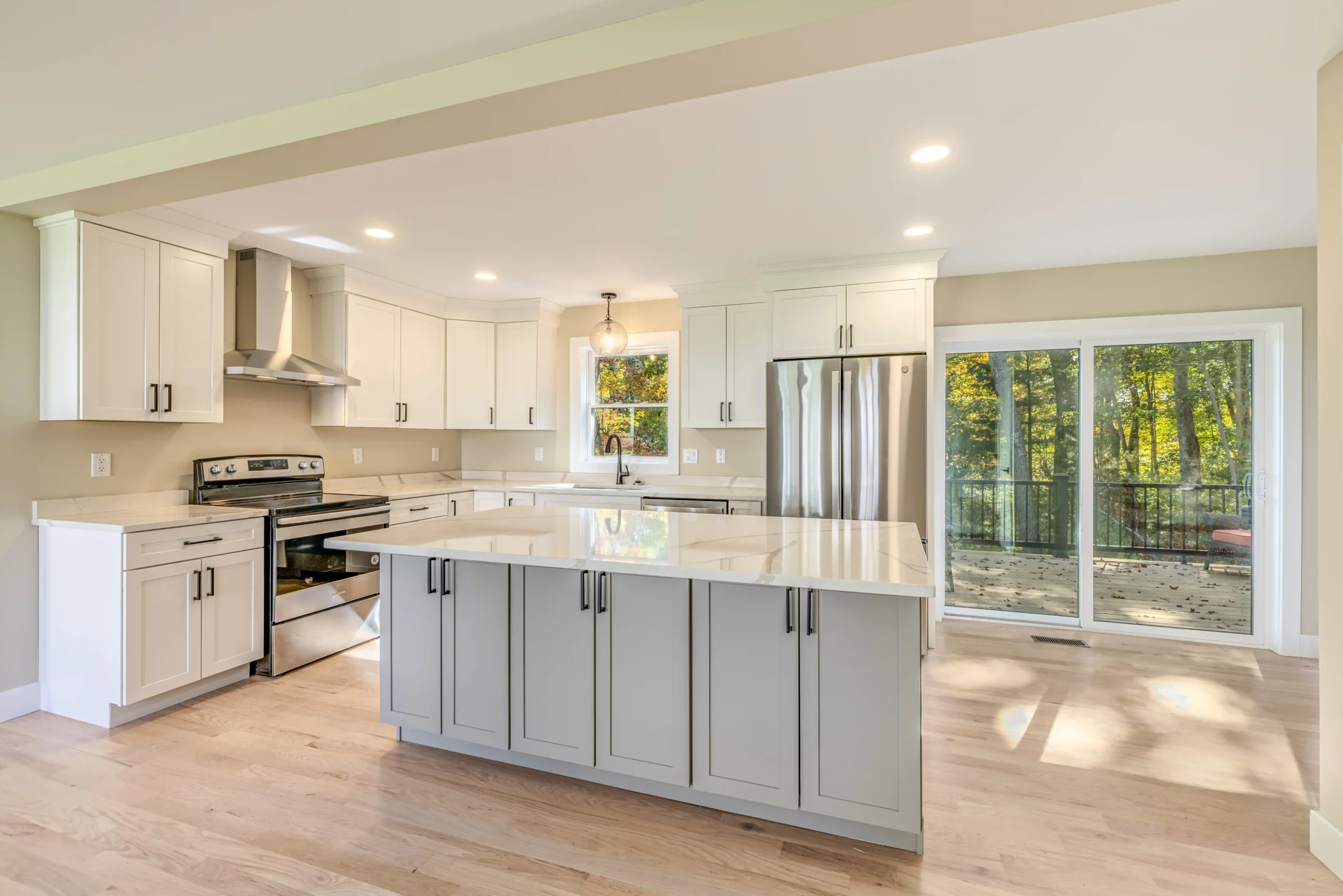 Crystal Lake Home 5 Elm Street Bright Modern white kitchen with stainless steel appliances, stone countertops and sliding glass doors