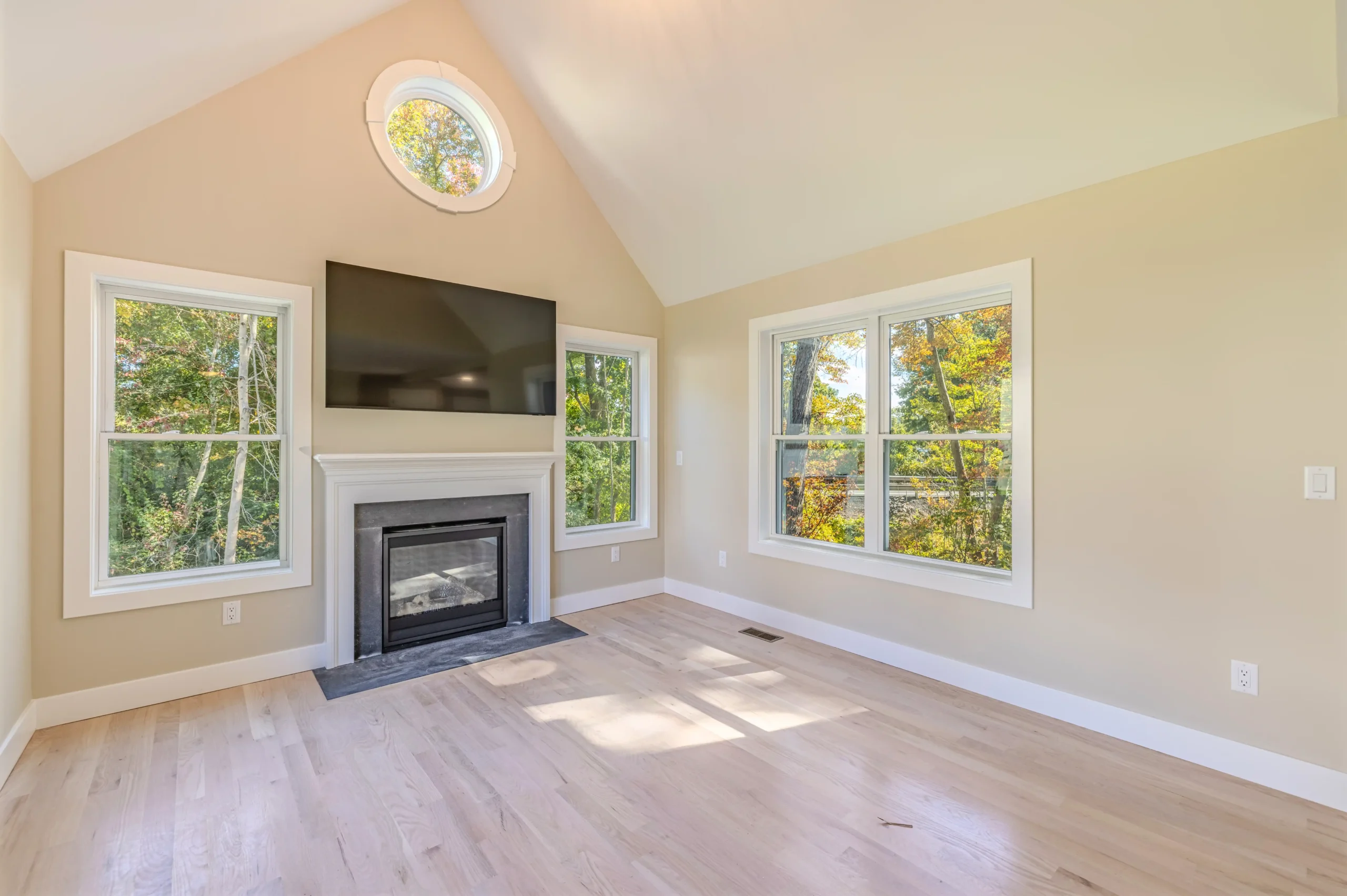 Crystal Lake Home 5 Elm Street Bright Bright living room with fireplace, mounted television and large windows overlooking trees