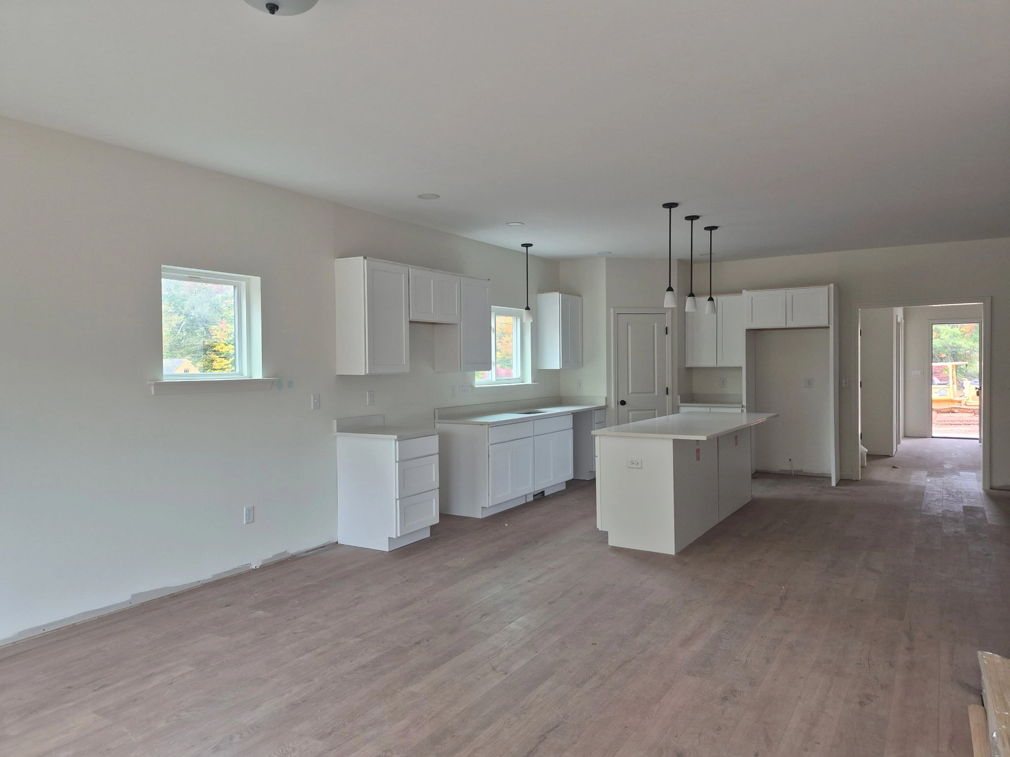 Edith Lane Beverly Farmhouse - Modern kitchen with white cabinets, center island and stainless steel range hood